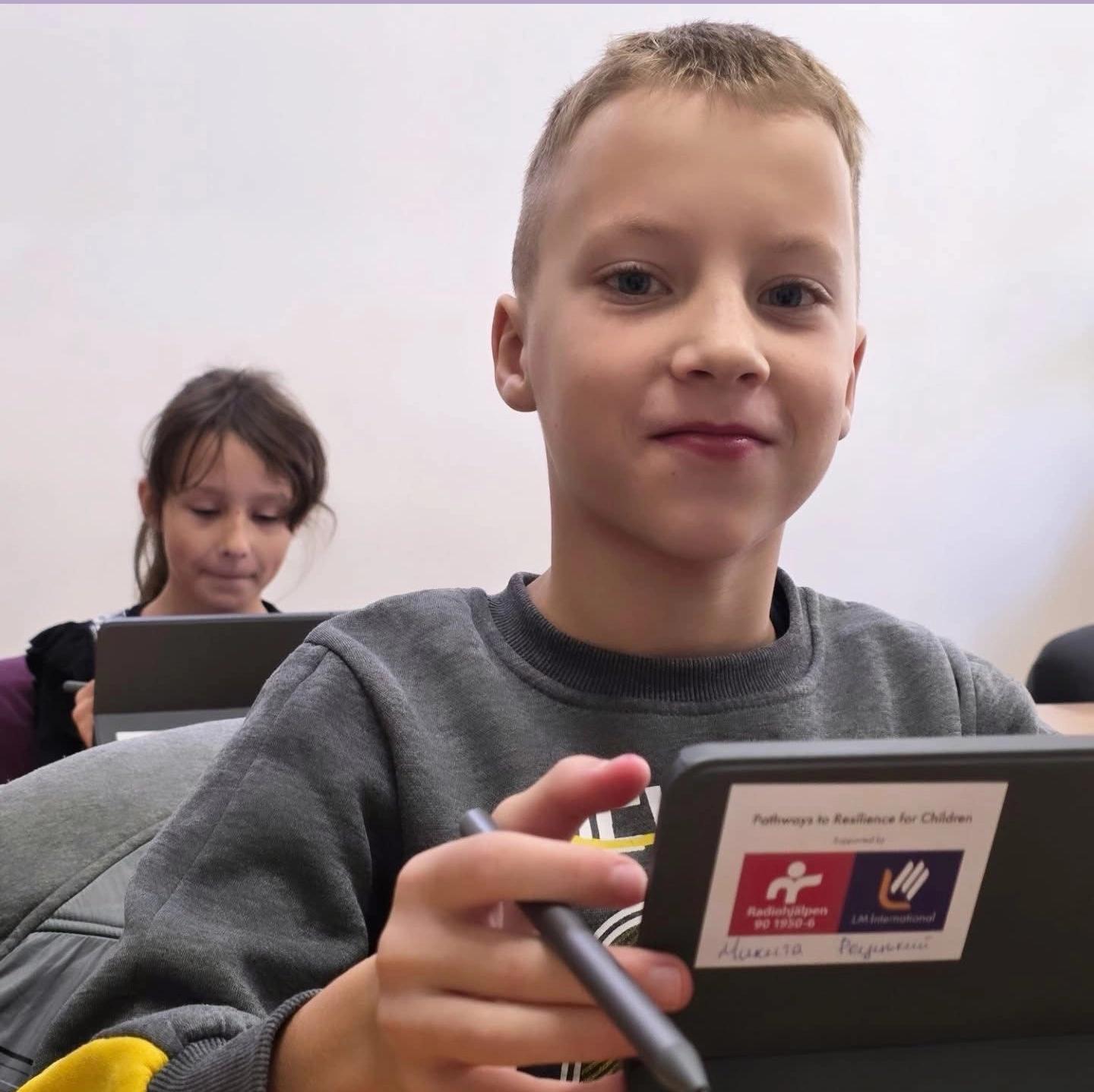 Pojke och flicka i Ukraina som gör skolarbete på sina surfplattor