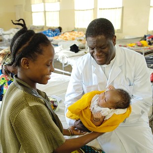 Dr Mukwege håller ett nyfött barn tillsammans med mamman på Panzi sjukhuset